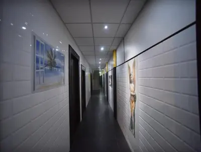 a hallway of a building with paintings on the walls at PRM Aruna Lodge in Erode