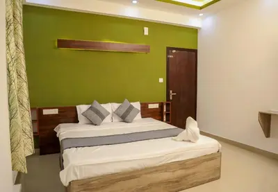 a bedroom with a bed with a green wall at J TEN Residency in Meenangadi