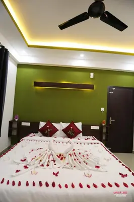 a bedroom with a large bed with red roses on it at J TEN Residency in Meenangadi