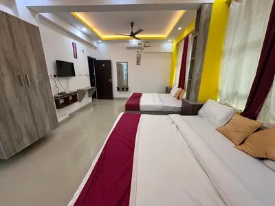 a hotel room with two beds and a tv at J TEN Residency in Meenangadi