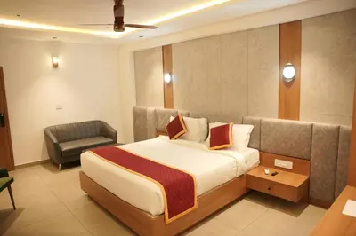 a hotel room with a bed and a chair at Denz Paradise in Kelakam