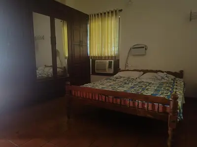 a bedroom with a bed and a window and a mirror at Utthara Tharavadu in Irinjālakuda