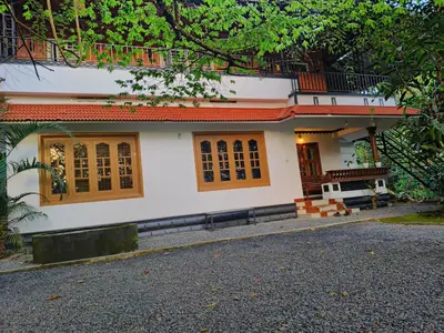 a white house with orange roof and windows at Wayanad Home stay in Kaniyāmbetta