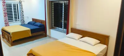 a bedroom with two beds and a window at Wayanad Home stay in Kaniyāmbetta