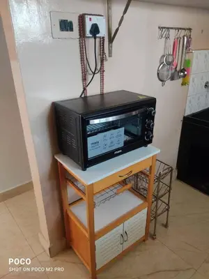 a microwave oven sitting on a table in a kitchen at Sumukh's house in Mysore