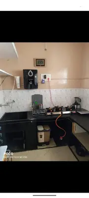 a kitchen with a black counter top and a sink at Sumukh's house in Mysore