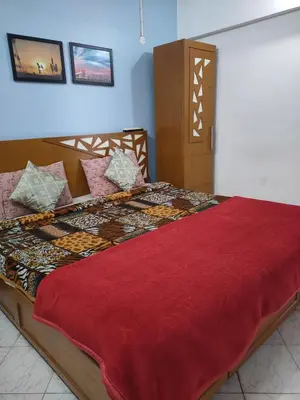 a bedroom with a bed with a red comforter at HILL view ooty HOME Stay in Coimbatore