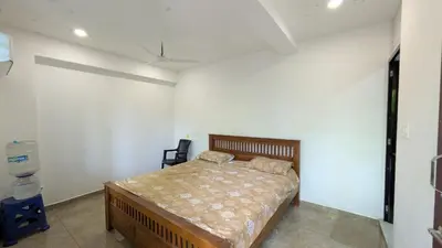 a bedroom with a bed in a white room at village stay Chittur Thathamangalam in Tattamangalam