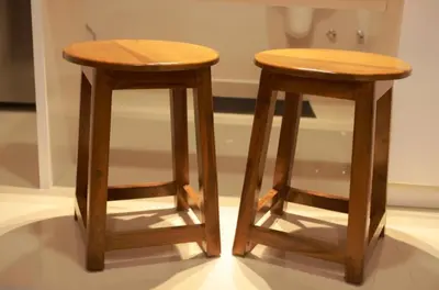two wooden stools sitting next to each other at LAVENDER AiRPORT SUiTE in Nedumbassery