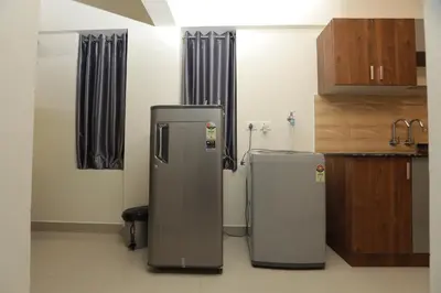 two refrigerators are sitting in a kitchen at LAVENDER AiRPORT SUiTE in Nedumbassery