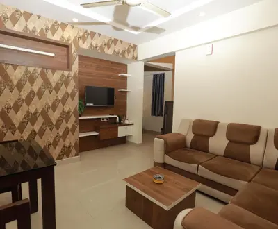 a living room with a couch and a tv at LAVENDER AiRPORT SUiTE in Nedumbassery