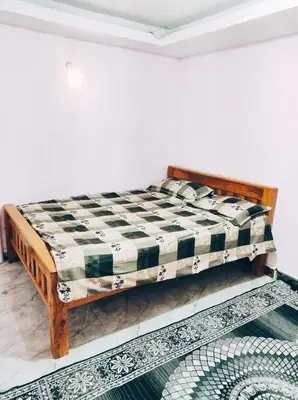 a bed in a room with a checkered mattress at Mysore City Vibe By A1k in Mysore
