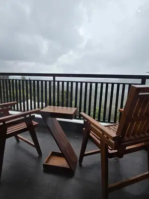 two benches and a table on a balcony at Indhraprashtham in Aruvankadu
