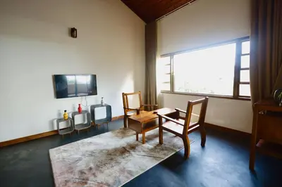 a living room with chairs and a table and a tv at Calithra Boutique Resort in Chithragiri
