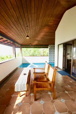 a living room with a table and two chairs at Calithra Boutique Resort in Chithragiri