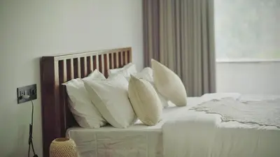 a bedroom with a bed with white pillows at Calithra Boutique Resort in Chithragiri