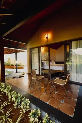 a patio with a table and chairs and a bed at Calithra Boutique Resort in Chithragiri