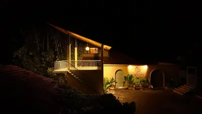 a house lit up at night with a balcony at Calithra Boutique Resort in Chithragiri