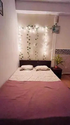 a bedroom with a large bed with lights on the wall at SKYRIN Bliss in Mysore