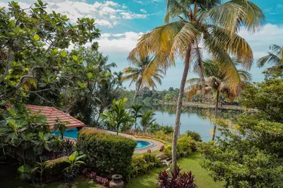 a view of a pond with palm trees at Madilina Heritage Villa in Parūr