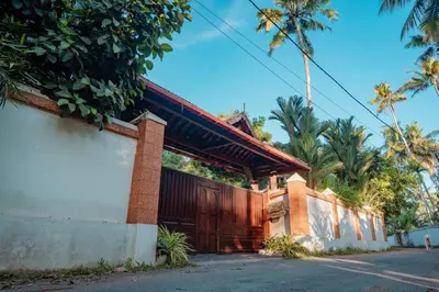 a house with a wooden gate on the side of a street at Madilina Heritage Villa in Parūr