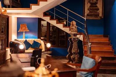 a living room with blue walls and stairs at Madilina Heritage Villa in Parūr