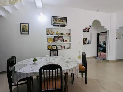 a dining room with a table and chairs and a room at Gods Gift Homestay James Inn in Kozhikode
