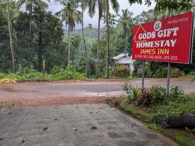 a sign on the side of a road at Gods Gift Homestay James Inn in Kozhikode