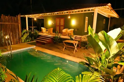a backyard with a swimming pool and a house at Mcafe Private Pool Plantations by Greenescapes in Kenichira