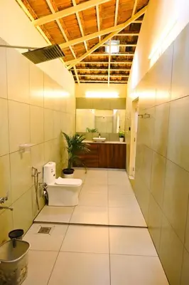 a bathroom with a toilet and a sink at Mcafe Private Pool Plantations by Greenescapes in Kenichira