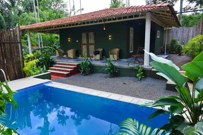 a villa with a pool in a garden at Mcafe Private Pool Plantations by Greenescapes in Kenichira