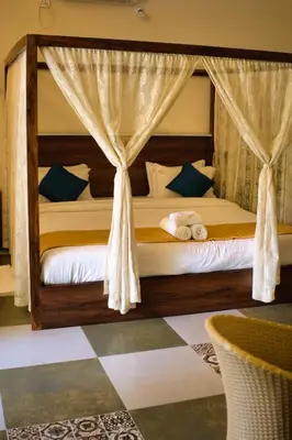 a bedroom with a bed with a canopy at Mcafe Private Pool Plantations by Greenescapes in Kenichira