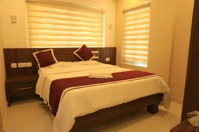 a large bed in a bedroom with a window at Ambalath whitespring in Guruvāyūr