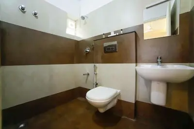 a bathroom with a toilet and a sink at Ambalath whitespring in Guruvāyūr