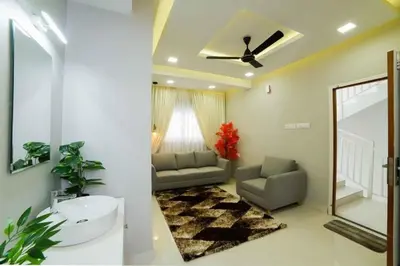 a living room with a couch and a ceiling fan at Ambalath whitespring in Guruvāyūr