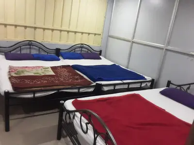 two beds in a small room with windows at SGH Mysore dorm bus rail station in Mysore
