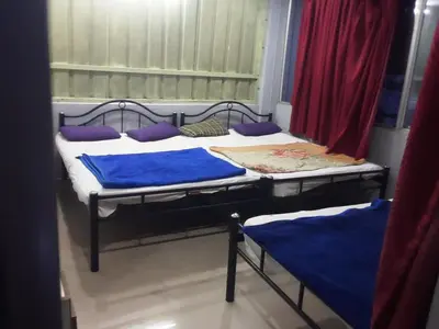 two beds in a room with purple pillows at SGH Mysore dorm bus rail station in Mysore