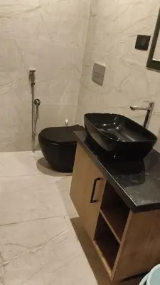 a bathroom with a black sink and a toilet at LA VILLA Resort in Vythiri