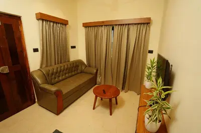 a living room with a couch and a table at LA VILLA Resort in Vythiri