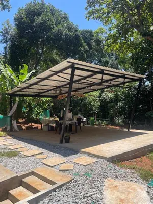 a wooden pavilion with a table and chairs under it at Calm Ville in Ponnampet