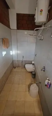 a small bathroom with a toilet in a room at Atithi Devo Resort Coorg by LexStays in Kushālnagar