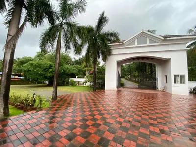 a brick driveway in front of a house with palm trees at Hotel KPM Tripenta in Palakkad