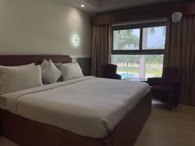 a bedroom with a large bed and a window at Hotel KPM Tripenta in Palakkad
