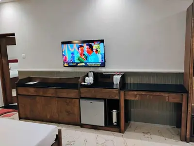 a flat screen tv sitting on top of a desk at Hotel KPM Tripenta in Palakkad