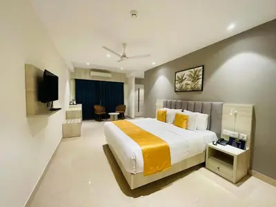 a hotel room with a large bed and a television at Hotel Golden Couch in Badagara