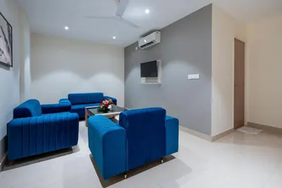 a waiting room with blue chairs and a table at Hotel Golden Couch in Badagara