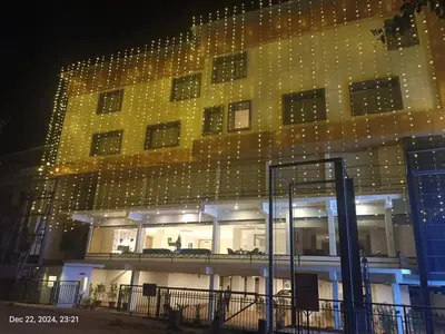 a building with christmas lights on the side of it at Hotel Golden Couch in Badagara