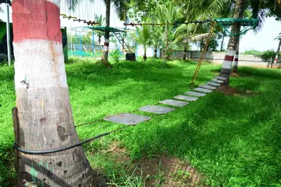 a rope tied to a palm tree in a park at Lucky Escape Adda in Hullahalli