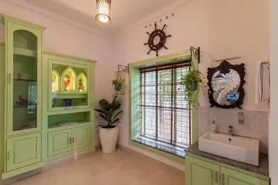 a bathroom with green cabinets and a sink and a window at GEE DE Homes in Kizhake Chālakudi