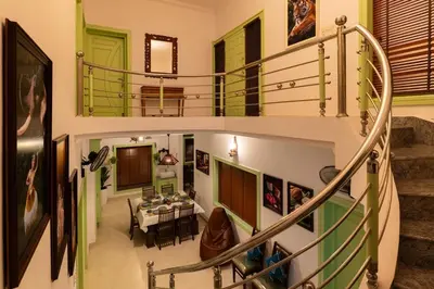 a spiral staircase with a dining room in a house at GEE DE Homes in Kizhake Chālakudi